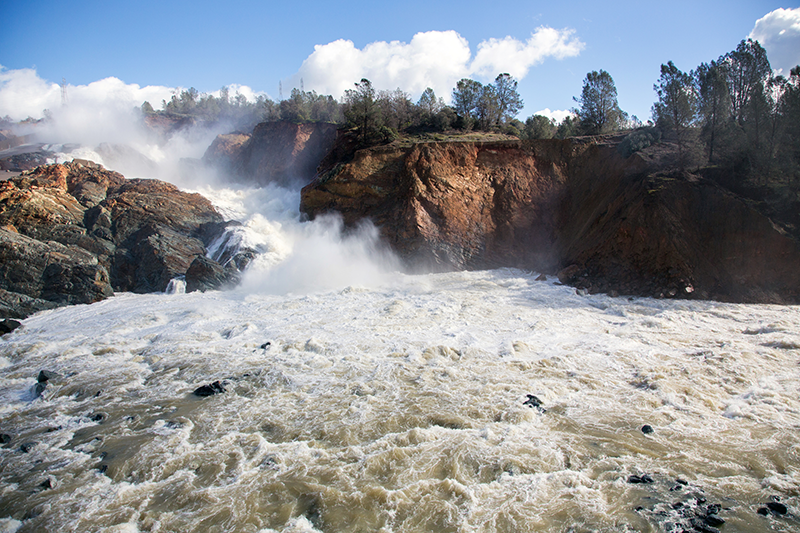 View of water flowing below the damaged spillway at Oroville Dam in Feb 2017